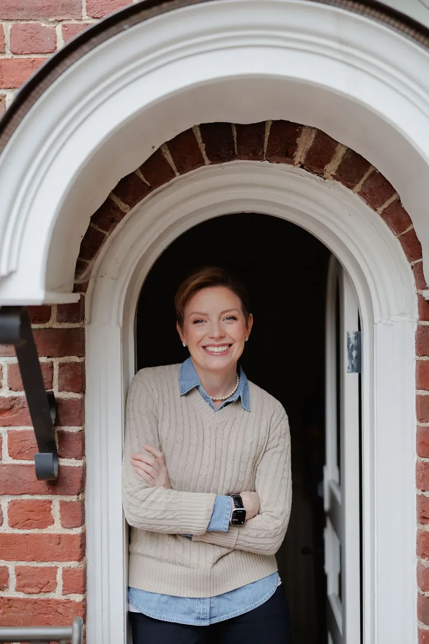 Stephanie Gooding smiling in an arched brick doorway