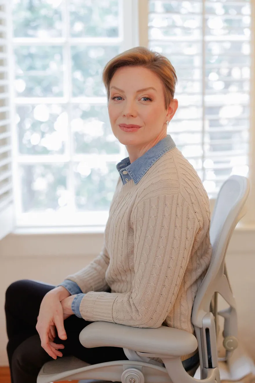 Stephanie Gooding seated by a sunlit window, looking toward the camera